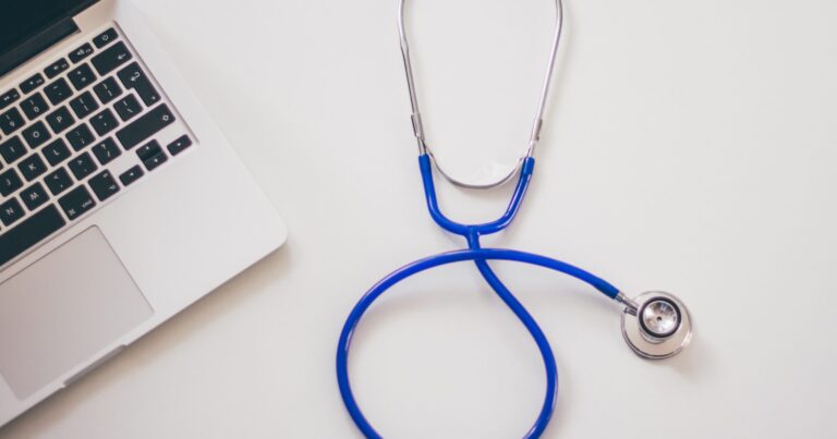 stethoscope next to a laptop