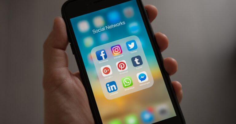 hand holding phone showing social icons