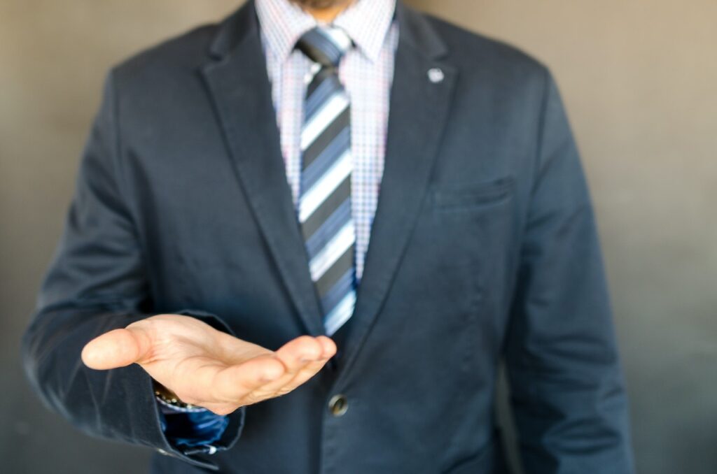 man in suit holding out his hand