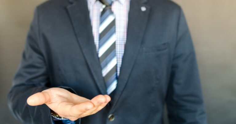 man in suit holding out his hand